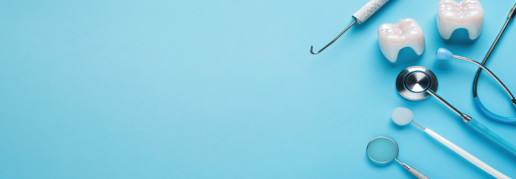 Dental tools and two tooth models on right side of light blue background, creating a clean, clinical, and professional look.